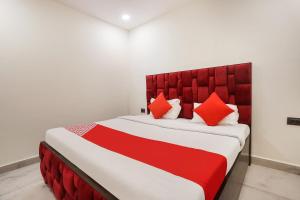 a bedroom with a large bed with a red headboard at OYO Flagship Star Stay in New Delhi