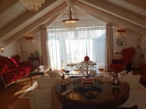 ein Wohnzimmer mit Sofas, einem Tisch und einem Kronleuchter in der Unterkunft Penelope suite 