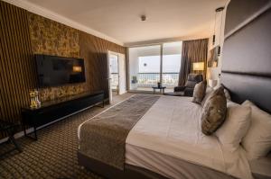 a hotel room with a large bed and a television at David Dead Sea Resort & Spa in Ein Bokek