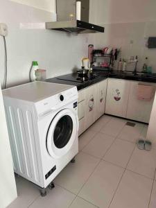 een keuken met een wasmachine bij TT3 Soho@Tabuan Tranquility near Unimas,Tunku Putra in Kuching