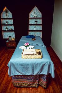 a bed with a blue blanket and a basket on it at Vannasut Hotel and Spa in Kathmandu