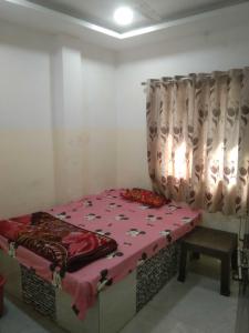 a bedroom with a bed with a pink blanket on it at SPOT ON Hotel Rs Inn in Nagpur