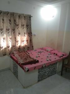 een kamer met een bed met een roze deken erop bij SPOT ON Hotel Rs Inn in Nagpur