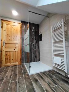een badkamer met een douche en een glazen deur bij Farmhouse Soklic in Bohinj