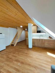 een woonkamer met een houten plafond en een trap bij Farmhouse Soklic in Bohinj
