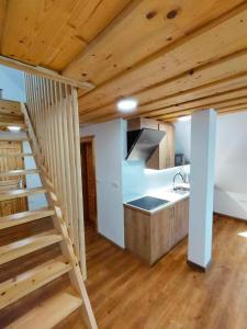 una cocina con una escalera que conduce a un loft en Farmhouse Soklic en Bohinj