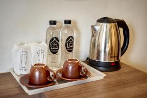 a tray with two cups and two bottles of water at H Hotel Phrasing in Chiang Mai
