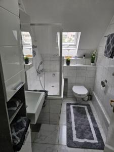 y baño con aseo, bañera y lavamanos. en Exklusives und helles Dachgeschoss-Apartment No 1 im Zentrum von Kassel, schnelles 1Gbit Internet, Geschirrspüler, Boxspringbetten, en Kassel