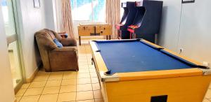 a living room with a pool table and a chair at Gooderson Leisure Silver Sands 1 Self Catering and Timeshare Lifestyle Resort in Durban