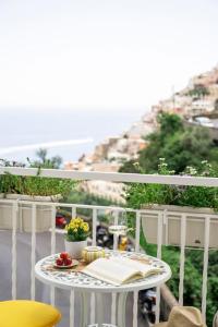a table with a book on a balcony with a view at House on the rock in Positano