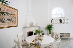 a white dining room with a white table and chairs at House on the rock in Positano +35 photos
