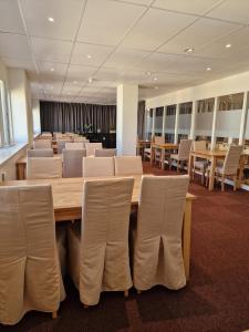 une salle de conférence avec une grande table et des chaises en bois dans l'établissement Hotell City, à Härnösand