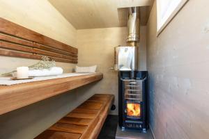 a tiny kitchen with a stove and a fireplace at Arctic Circle Beach House in Meltosjärvi