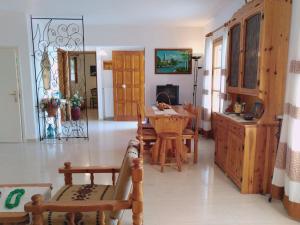 ein Wohnzimmer mit einem Holztisch und Stühlen in der Unterkunft Explore Aegina Island in Souvala
