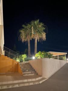 eine Treppe mit zwei Palmen vor einem Gebäude in der Unterkunft Case Vesta in Villasmundo