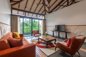 Una sala de estar con un sofá y sillas y un televisor. en Villa Sereno by StayVista - An elegant and entertaining retreat featuring a swimming pool, outdoor jacuzzi, modern interiors, and a snooker table, en Alibaug