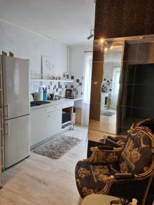 a kitchen with a refrigerator and a chair in it at Dviejų kambarių butas in Kaunas