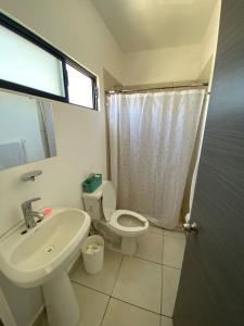 uma casa de banho branca com um lavatório e um WC em Casa en Mazatlán em Mazatlán