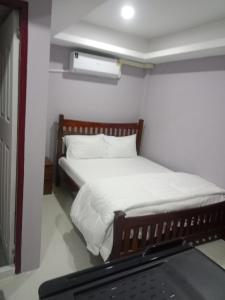a bedroom with a bed with white sheets at Tulsi Inn at Walking Street in Pattaya South