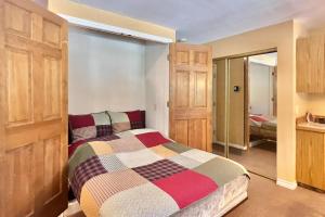 1 dormitorio con 1 cama y puerta corredera de cristal en On the Rapids - B Unit, en Grand Lake