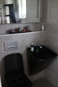 La salle de bains est pourvue de toilettes noires et d'un lavabo. dans l'établissement Ferienhaus in Istanbul, à Sarıyer