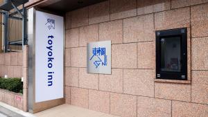 a building with a sign on the side of it at Toyoko Inn Iwakuni eki Nishi guchi in Iwakuni