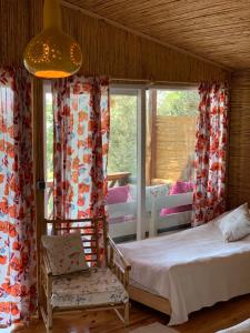 a bedroom with a bed and a chair and a window at Large Bungalow with Sea View in Kabak Bay, Ölüdeniz in Fethiye