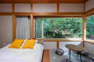 a bedroom with a bed and a large window at S-villa Karuizawa - Princeland - in Tsumagoi