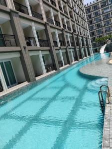 a large swimming pool in front of a building at Pretty nice pool view一楼泳池景观房 in Jomtien Beach