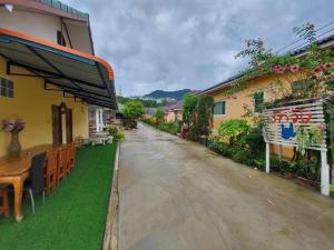 an empty street in a village with tables and chairs at Tassana House in Khao Kho