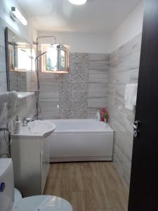 Baño blanco con bañera y lavamanos en Casa Bocan, en Geoagiu Băi