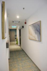 a hallway in a hospital with a painting on the wall at Homi Breeze 和逸微风 in Kota Kinabalu