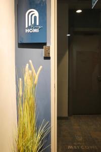 a sign on the wall of a building with a plant at Homi Breeze 和逸微风 in Kota Kinabalu