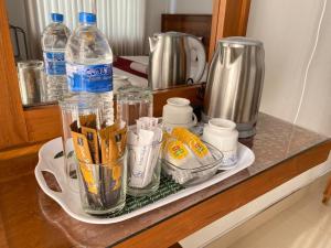 a counter with a tray with cups and bottles of water at Shani Residence Kandy in Kandy