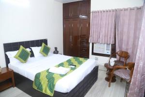 a bedroom with a bed and a chair in a room at Fortune Home Service Apartment 3Bhk,B-57 Sarita Vihar in New Delhi