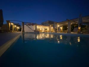 een zwembad 's nachts met de lichten aan bij Tenuta Palmira agriturismo in Salve