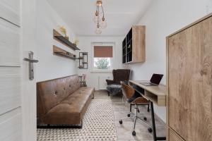 una oficina con sofá y escritorio en Spacious Apartment suitable for Remote Work with Balcony & Parking by Renters, en Wroclaw