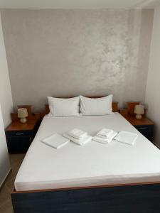 duże białe łóżko z trzema książkami w obiekcie Villa Marija **** with private pool w Budvie