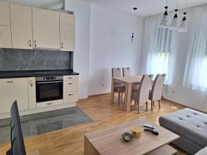 a kitchen and living room with a table and chairs at Apartman Una banjaluka in Hiseti