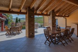 an outdoor patio with a wooden table and chairs at Villa La Martina in Canelli