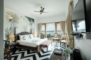 a bedroom with a bed and a large window at Burj Baneria - A Boutique Homestay in Udaipur