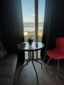 a table and a chair in a room with a window at Villa Twins in Nov Dojran