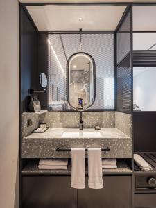 La salle de bains est pourvue d'un grand lavabo et d'un miroir. dans l'établissement Ramada Plaza by Wyndham Chungjang, à Gwangju