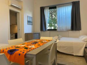 Habitación con mesa, cama y ventana en Residenze Arancio - con Wi-Fi e Servizio spiaggia - Narramondo Villas, en Giulianova
