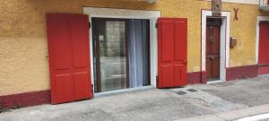 dwa czerwone drzwi na boku budynku w obiekcie 2 Pieces indépendant Peone-Valberg w mieście Péone