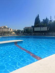 a large swimming pool with blue water at La Casa Azul - next to the sea! in Torrenueva