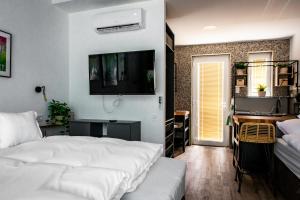 ein Schlafzimmer mit einem Bett und einem TV an der Wand in der Unterkunft Tisza Camping Apartmanház in Rakamaz