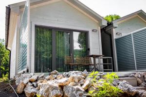 a patio with rocks in front of a house at Tisza Camping Apartmanház in Rakamaz