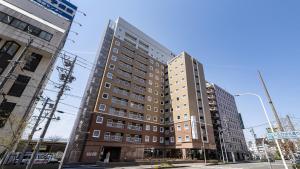 un edificio alto en la esquina de una calle en Toyoko Inn Matsumoto eki Higashi guchi, en Matsumoto
