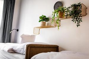 a bedroom with plants on the wall and a bed at Tisza Camping Apartmanház in Rakamaz